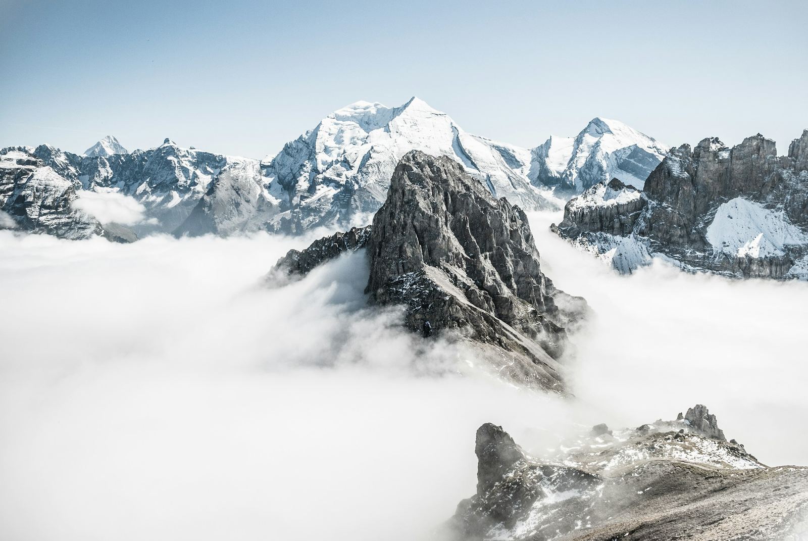 Snow-covered mountain peak rising above the clouds