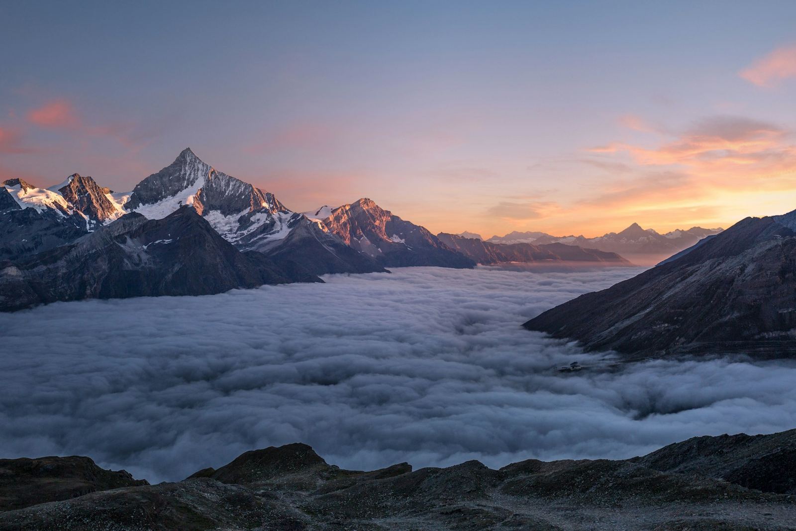 Alpine summit above a sea of clouds at sunrise